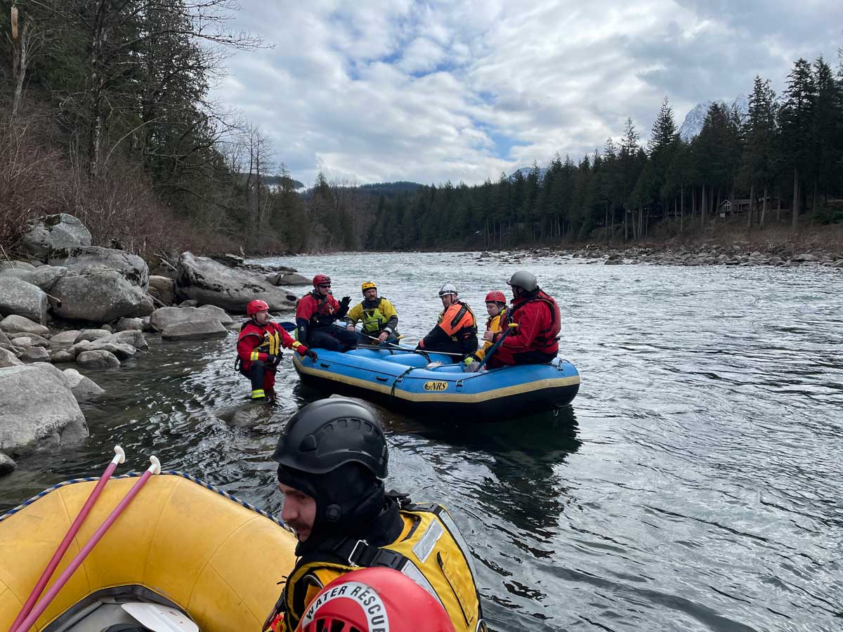 Group of fire fighters undergoing training in boat on water